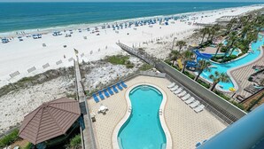 Resort com piscina, praia e palmeiras.