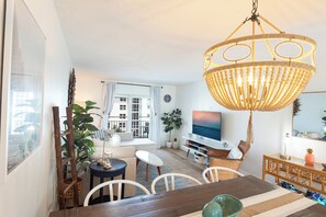 Relax in a spacious living room with a comfortable seating area, dining table, and large window.