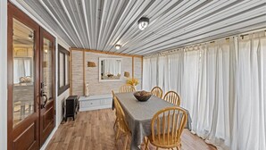 A dining area with a long table, wooden chairs, and a modern ceiling design.
