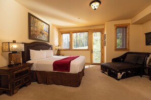 A bedroom with a large bed, a nightstand, a dresser, a sofa, and a window with blinds. - Alpenglow 10 - Managed by Purgatory (Durango)
