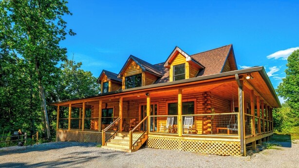 A log cabin with a covered porch, multiple windows, and a gravel driveway. - Lones Branch Lodge - Stunning new build! (Sevierville)