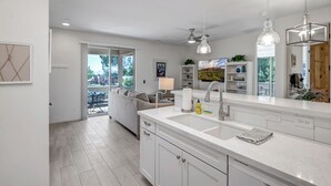 A modern kitchen with a large island, white cabinetry, and pendant lighting. - Experience luxury at Sedona Thunder Mountain Estate and Casita in West Sedona. (Sedona)