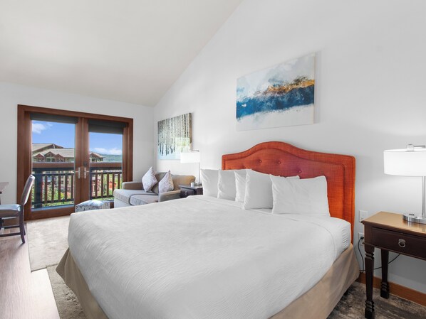 A hotel room with a large bed, a sofa, a desk, and a balcony with a view of the mountains. - Sundial C407-A | Ski-in/Ski-out | Village Views | Pools & Hot Tubs | Fitness Room (Park City)