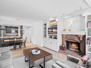 Cozy living space with a central fireplace, dining area, and kitchen.