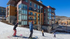 A multi-story building with large windows and balconies, likely a hotel or apartment complex. - LIFT 307-A | Ski-In/Out | Near Pool Deck | Mountain View | Hot Tub | Pool | Great Amenities (Park City)