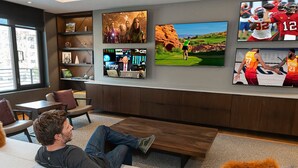 A modern lounge area with a large flat-screen TV displaying sports and movies, comfortable seating, and a view of the outdoors. - LIFT 307-A | Ski-In/Out | Near Pool Deck | Mountain View | Hot Tub | Pool | Great Amenities (Park City)