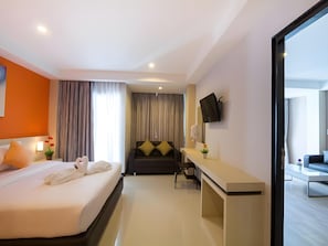 A hotel room with a bed, a desk, a sofa, and a TV mounted on the wall. - The Ozone Boutique Hotel (Udon Thani)