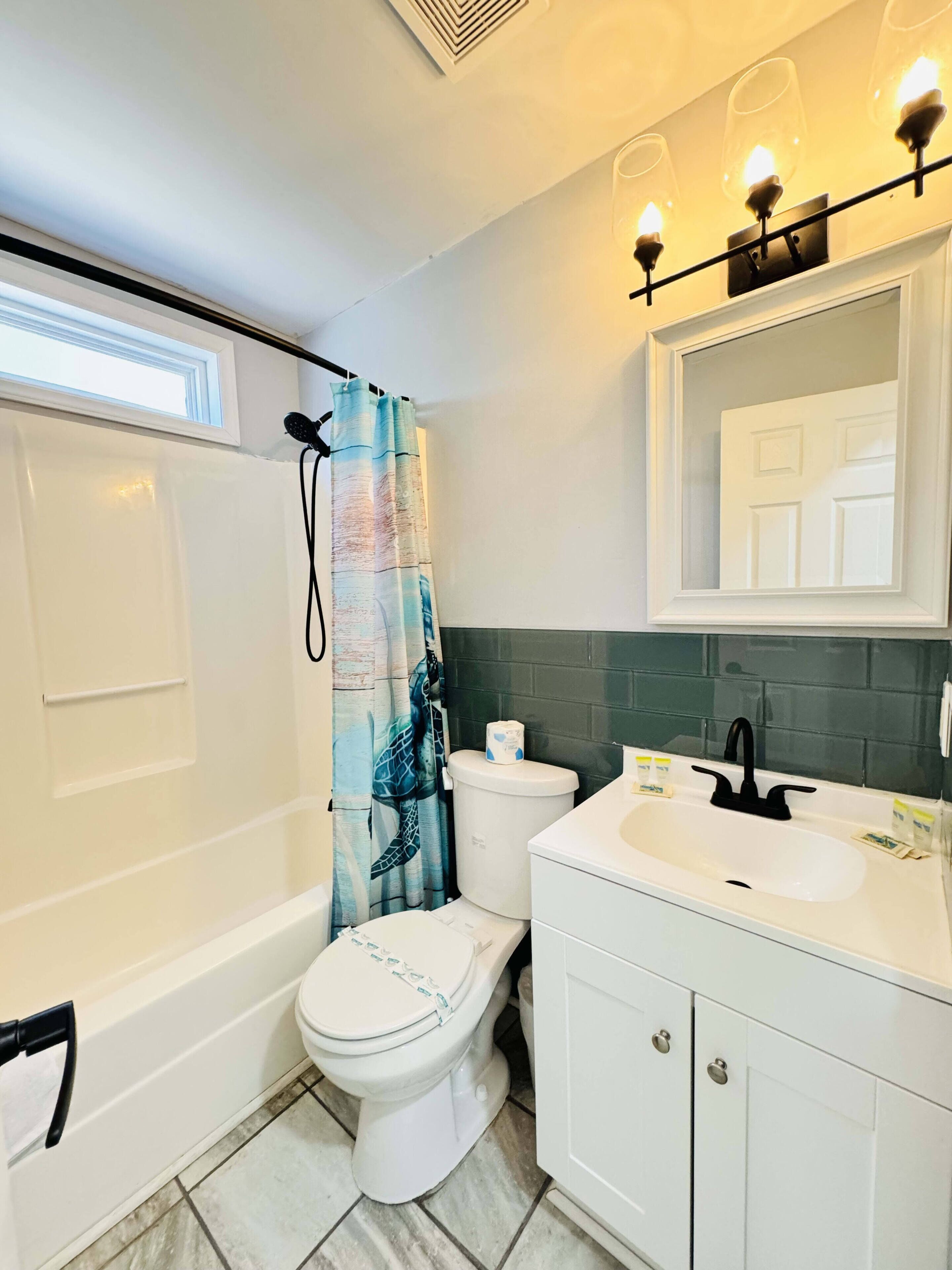 A bathroom with a bathtub, toilet, and sink.
