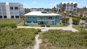 A two-story building with a flat roof, large windows, and a balcony. - Oceanfront Condo with Rocket Launch Views - Steps to Beach (Cocoa Beach)