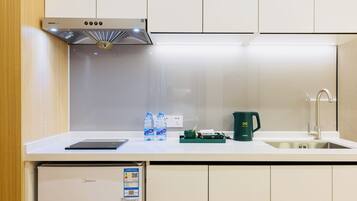 Una cocina equipada con campana extractora, pileta, cafetera y heladerita.
