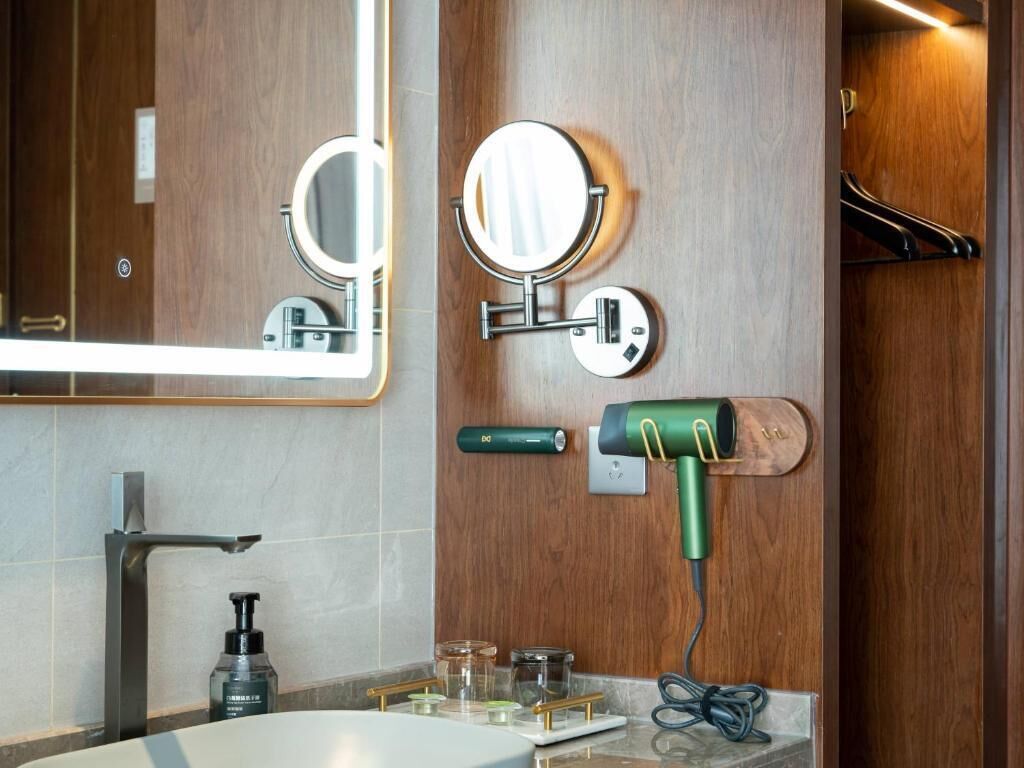 A bathroom with a mirror, a hairdryer, and a towel rack.
