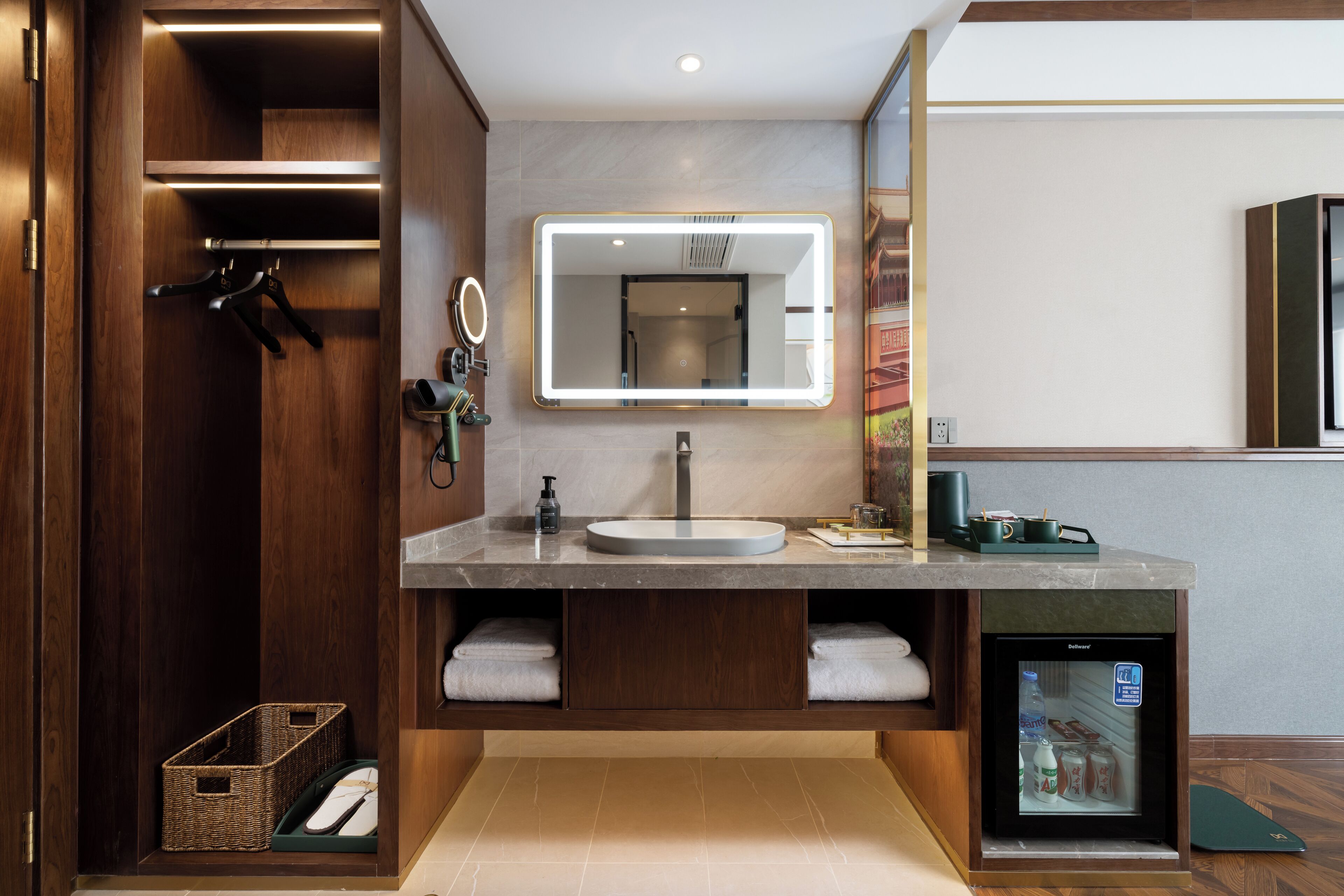 A modern bathroom with a vanity, mirror, and built-in refrigerator.