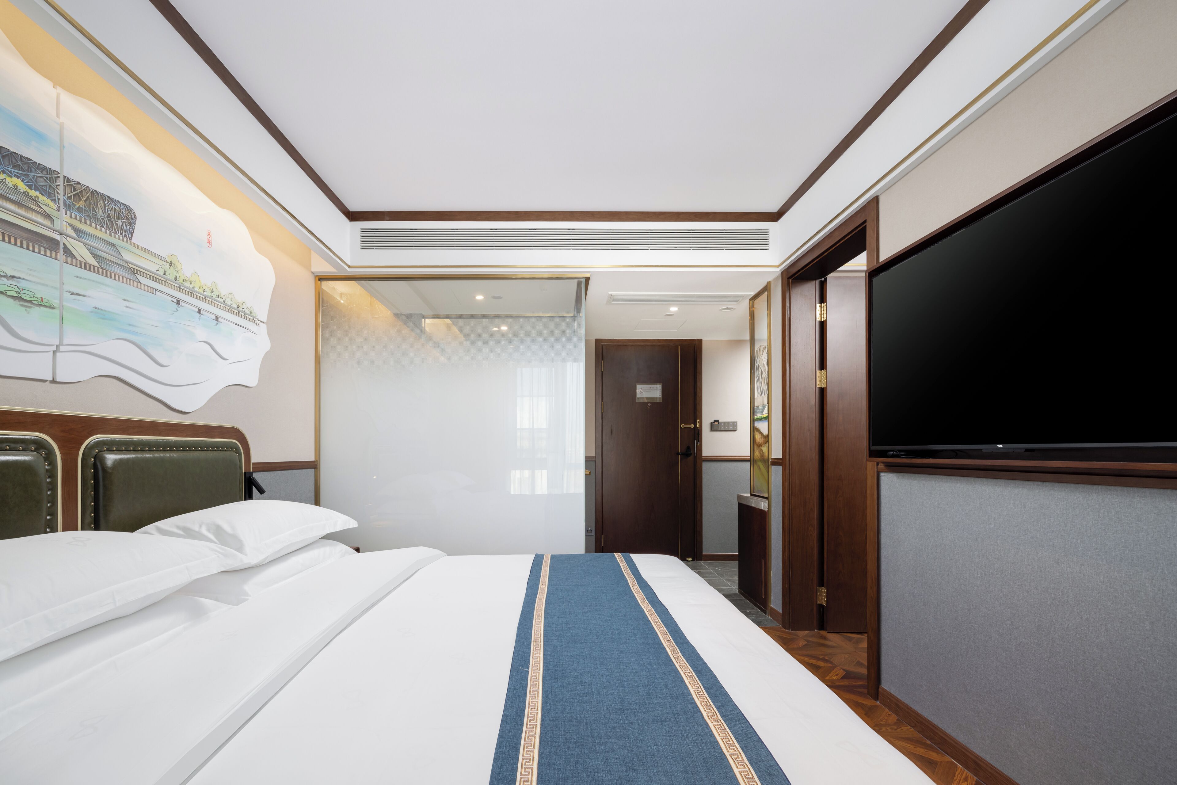 Una habitación de hotel con una cama, un televisor y un cuadro en la pared.