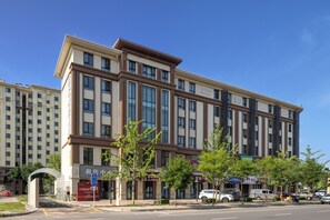 Un hôtel à plusieurs étages doté d’une façade moderne, de grandes fenêtres et d’une entrée imposante.