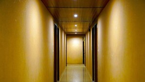 Un pasillo largo y estrecho con paredes amarillas y techo de madera.