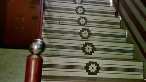 Una escalera con diseño estampado y barandilla roja.