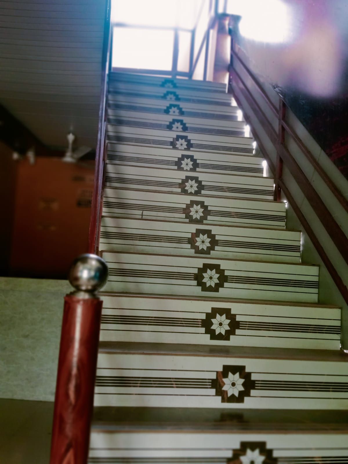 A staircase with a patterned design and a handrail.