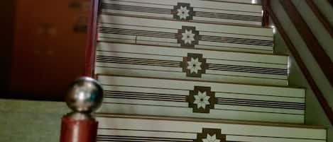 A staircase with a patterned design and a handrail.