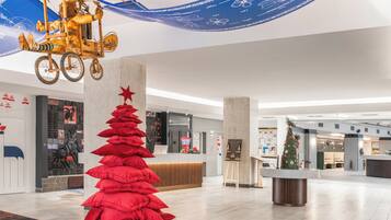 A modern lobby with a reception desk, a Christmas tree, and a unique hanging decoration.