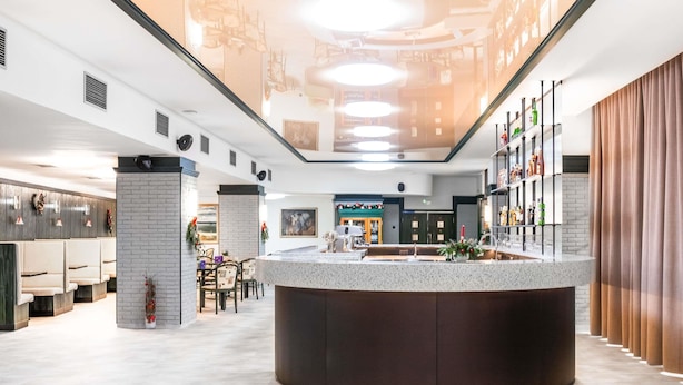 A modern hotel lobby with a central bar area, seating arrangements, and a reception desk. - Ibis Styles Relax Roznov pod Radhostem (Roznov Pod Radhostem)
