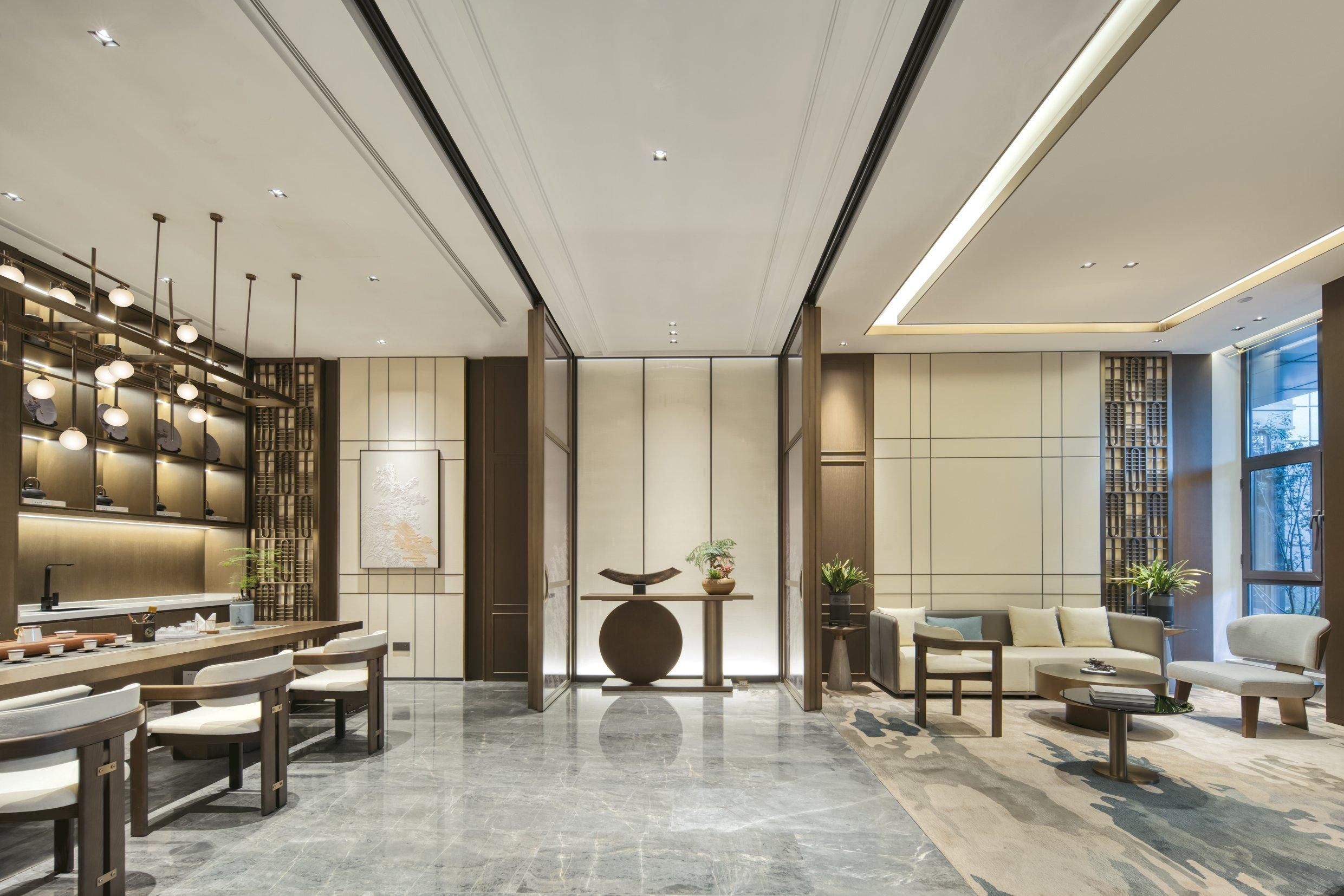 A modern hotel lobby with a central reception desk, seating area, and large windows offering views.