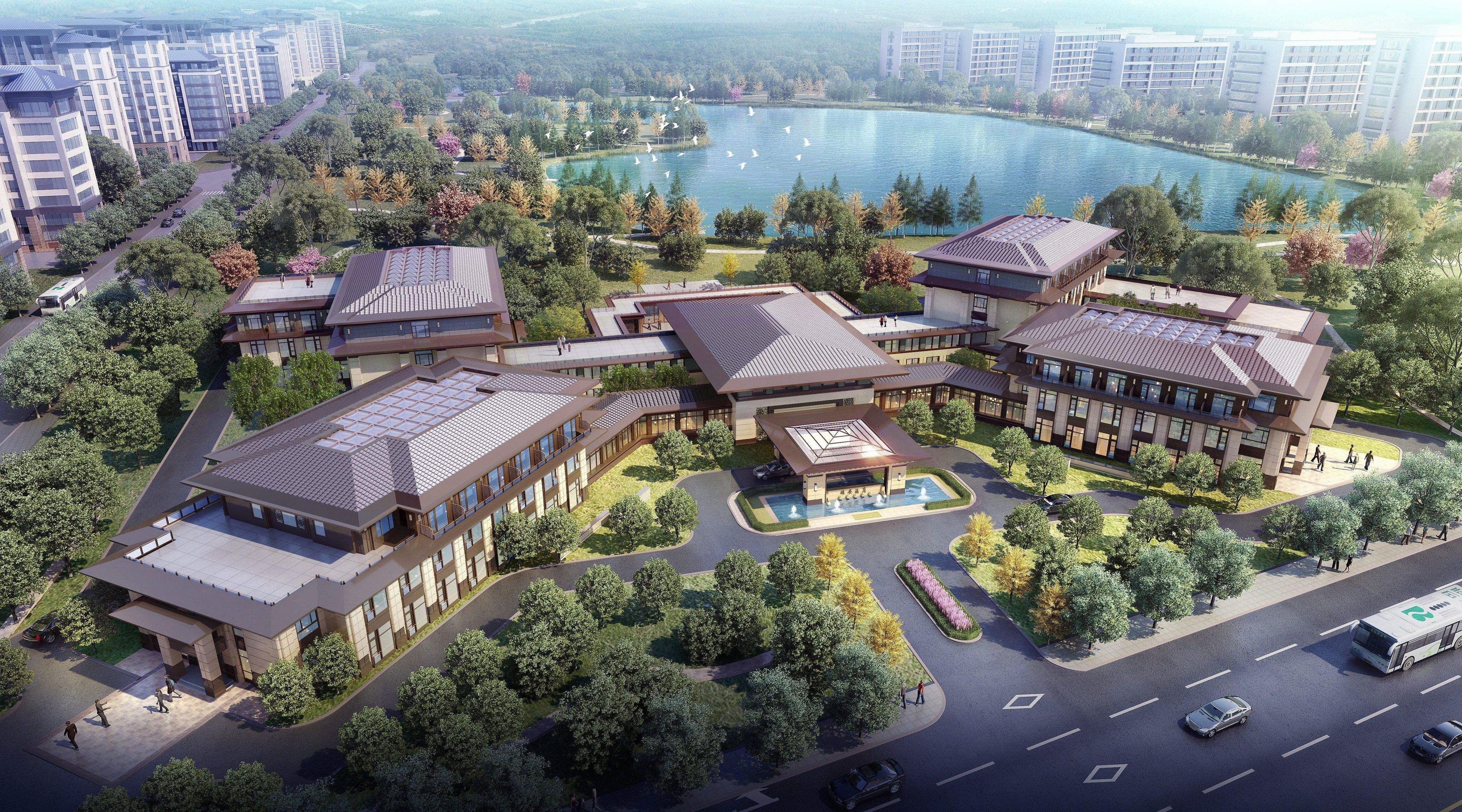 A modern hotel complex with multiple buildings, a central courtyard, and a lake view.