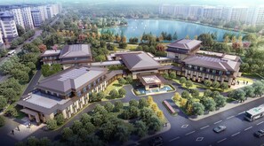 Un complejo hotelero moderno con varias construcciones, un patio central y vistas a un lago.