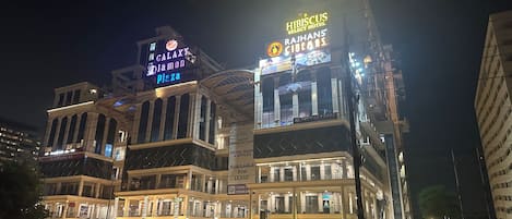 A multi-story hotel with illuminated signage for 'Galaxy Diamond Plaza' and 'Hibiscus Select Hotel'.