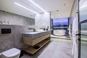 A modern bathroom with a marble vanity, a large mirror, and a bathtub visible through a glass partition. - Re'em Yarra Valley (Melbourne)