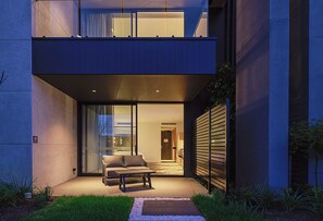 A modern building with a flat roof, large glass windows, and a visible interior with a sofa and a table. - Re'em Yarra Valley (Melbourne)