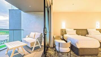 A hotel room with a balcony, a bed, a chair, and a table.