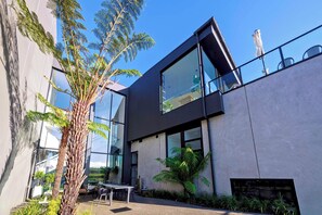 A modern building with large windows, a balcony, and outdoor seating. - Re'em Yarra Valley (Melbourne)