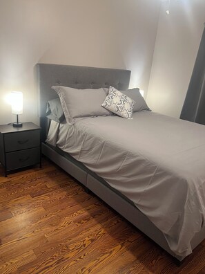 Cozy retreat with a single bed, bedside table, and lamp.