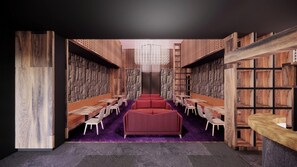 Una biblioteca con estanterías, zonas de descanso y un candelabro central.