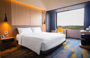 A modern hotel room with a large bed, a desk, and a view of the outdoors. - Aston Serang Hotel & Convention Center (Serang)