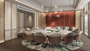 A modern dining area with a round table, multiple chairs, and a decorative light fixture. - Holiday Inn Xian East (Xi'an)