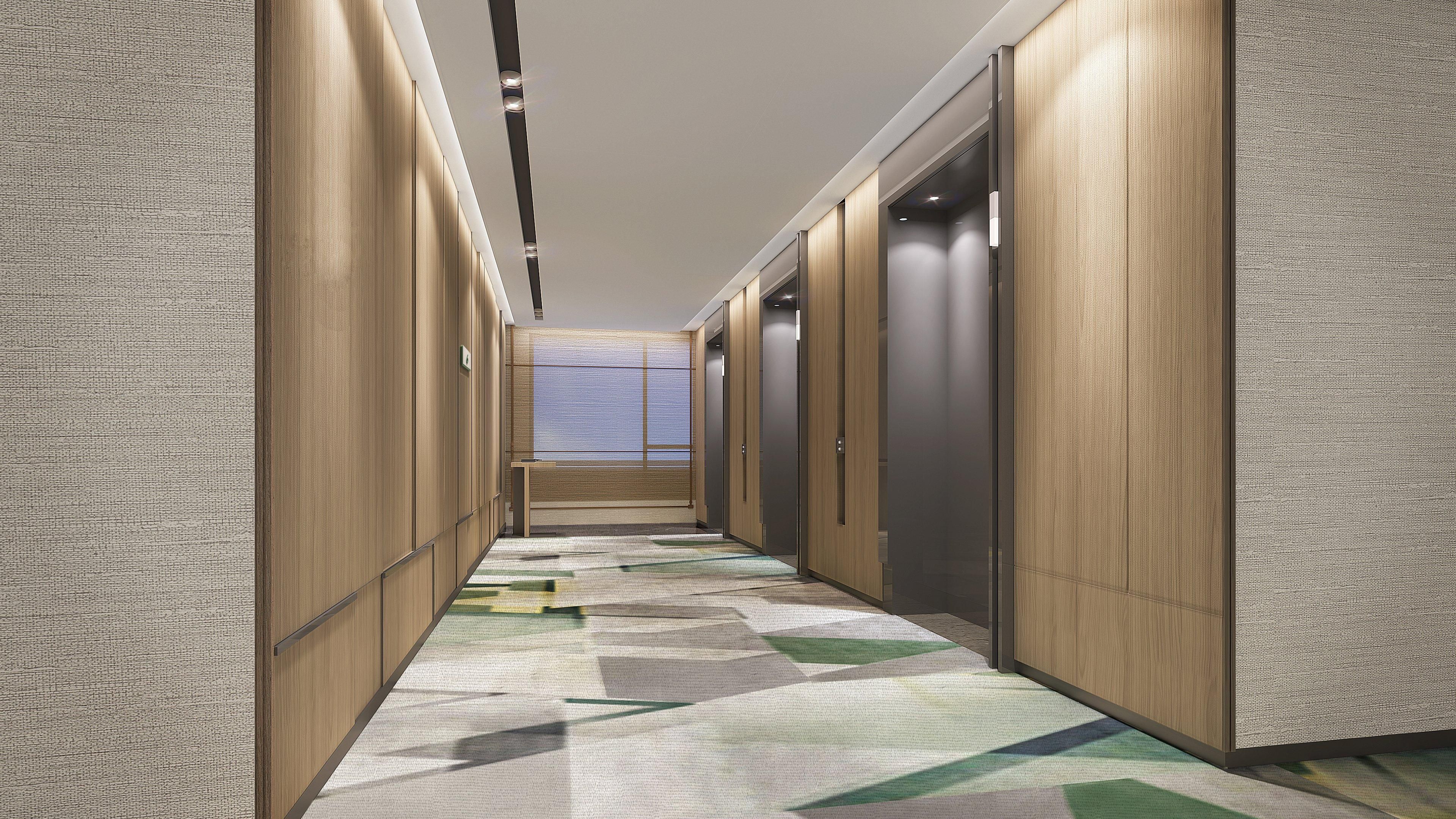 A modern hallway with wooden paneling, a patterned carpet, and a ceiling with recessed lighting.