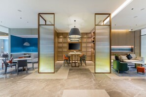 A modern interior with a dining area, seating, and a TV screen.