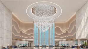 A spacious lobby with a large chandelier, vertical wooden slats, and a blue patterned wall. - Holiday Inn Express Zhoukou Dancheng An Ihg Hotel (Zhoukou)