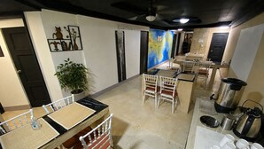 A hotel room with a dining area, a large window, a potted plant, and a map on the wall. - Panamá Experience Hostel (Panama City)