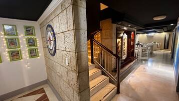 A hotel lobby with a marble staircase, a dining area, and a wall with framed pictures.