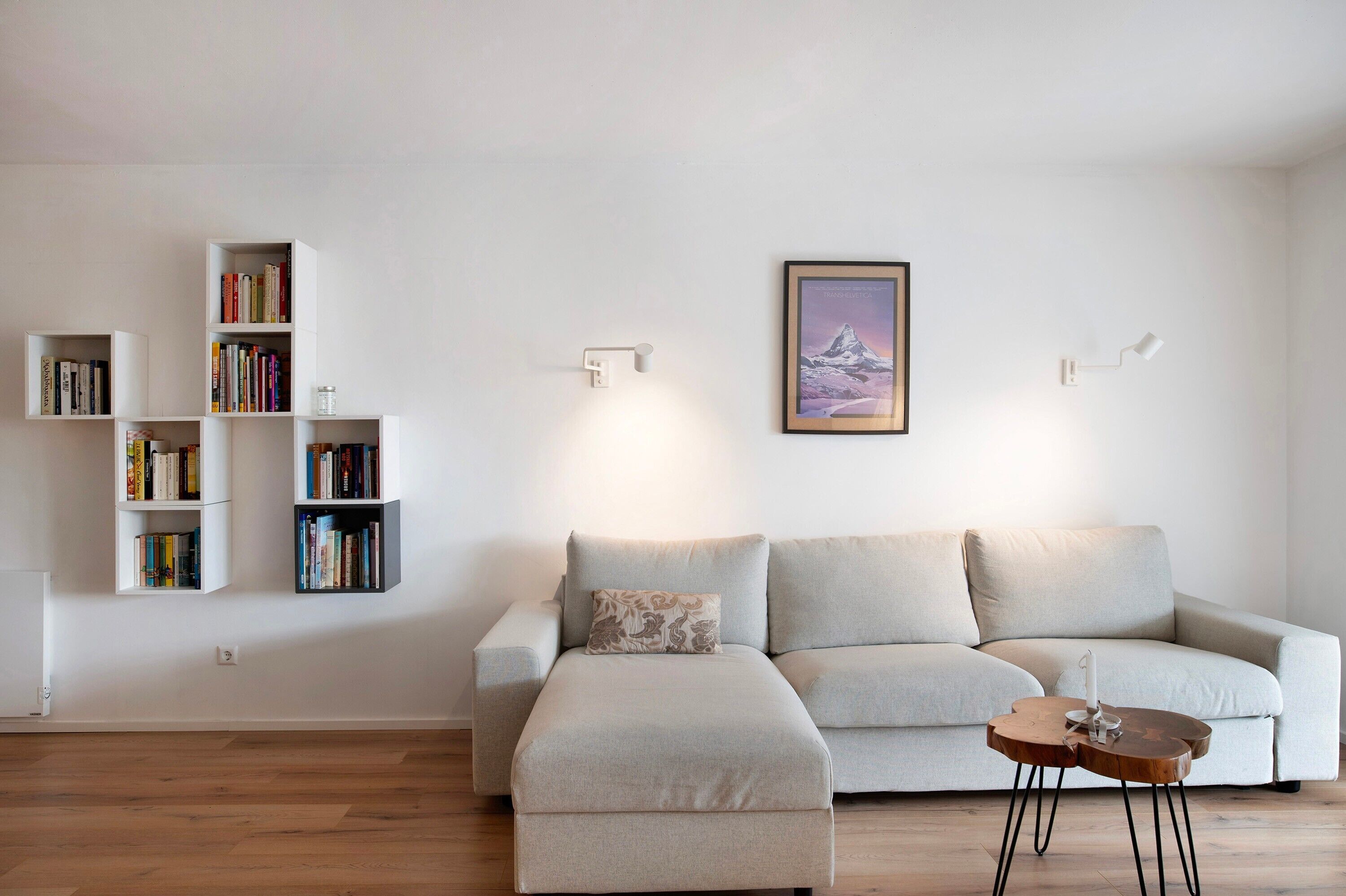 A living room with a sofa, a coffee table, and bookshelves against the wall.
