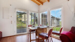 Un comedor con una mesa de madera, sillas y un sofá rojo.