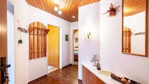A hallway with wooden paneling, a white wall, and a wooden door.