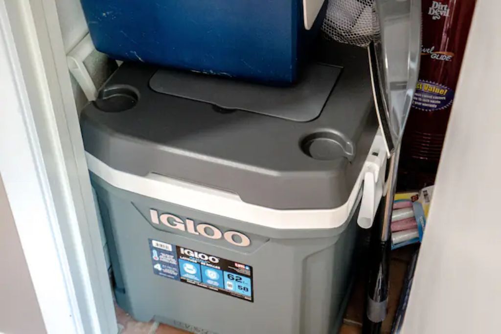 Un contenitore Igloo grigio e compatto con display digitale, posizionato in uno spazio stretto con stipite bianco.