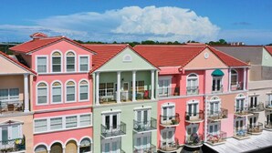 A row of colorful, multi-story buildings with balconies, likely residential apartments. - Elegant Condo - European Charm (Palm Coast)