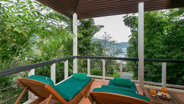 A covered balcony with wooden lounge chairs and a table with drinks. - Katamanda villa Sooksan Near Kata Noi Beach (Karon)