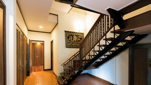 A hallway with a tiled floor, a wooden staircase, and a door at the end. - Katamanda villa Sooksan Near Kata Noi Beach (Karon)