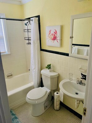 A bathroom with a bathtub, toilet, and sink.