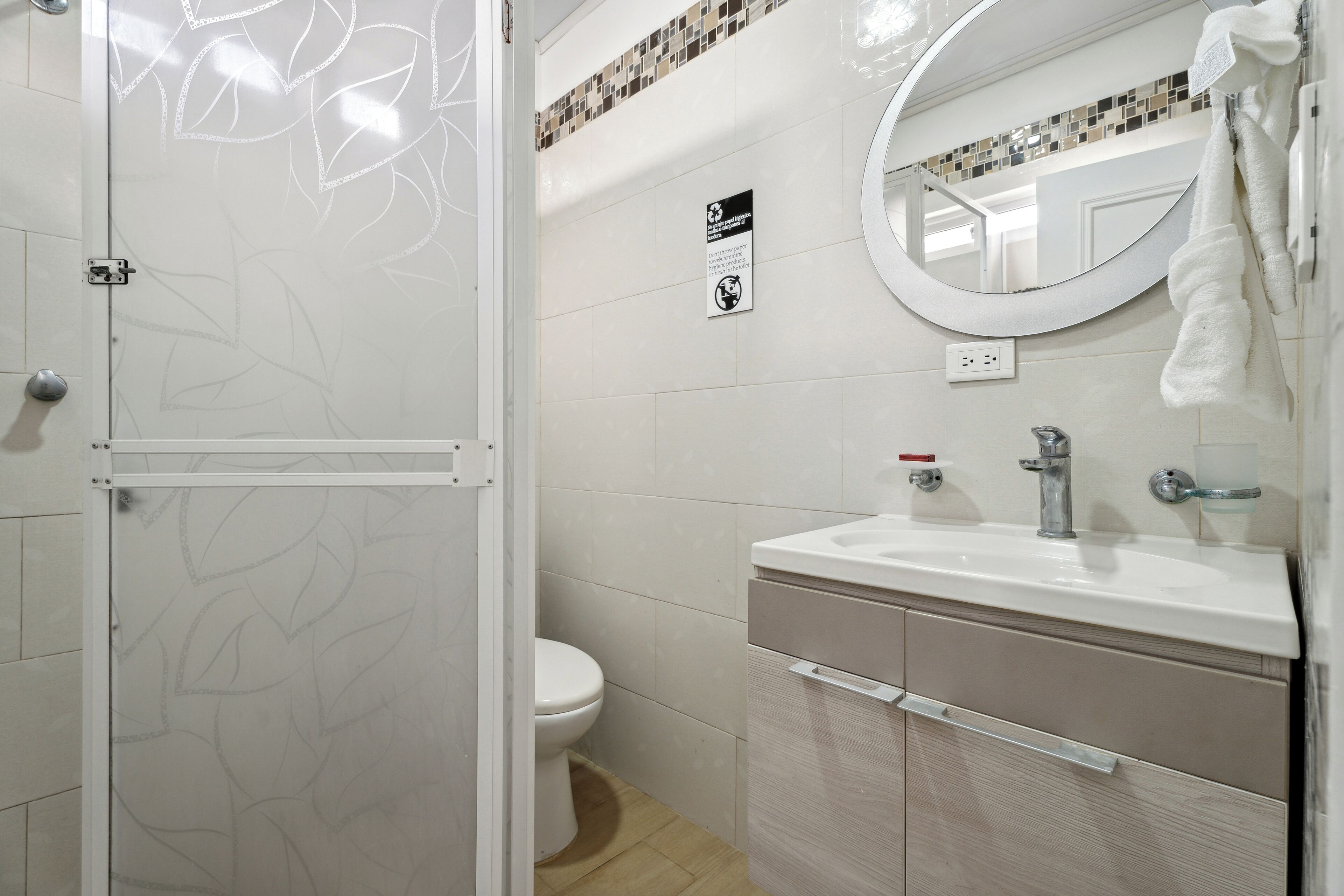 Un baño con inodoro, lavamanos y espejo.